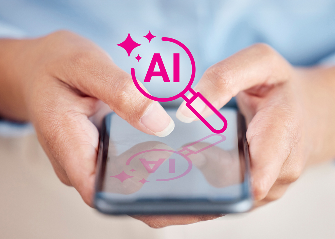 Woman holding a phone with an AI magnifying glass icon over it.